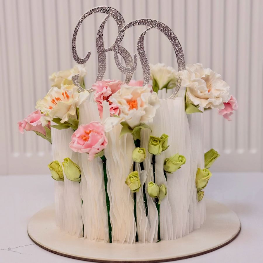 Tort de mireasă alb cu flori roz și monogramă din zahăr